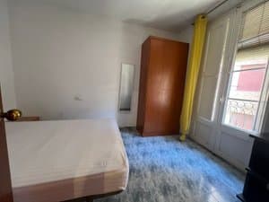 Dormitorio con cama, armario y balcón