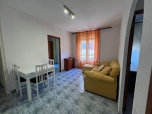 Salón comedor con sofá y mesa blanca