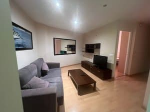 Salón con sofá, mesa baja y televisor