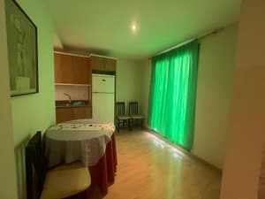 Comedor con mesa, frigorífico y ventanal con cortinas