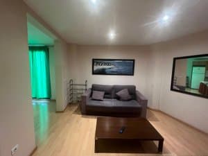 Salón con sofá gris y espejo