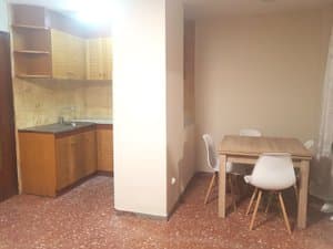 Cocina comedor con mesa de madera y sillas blancas