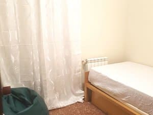 Dormitorio con cama individual y puf