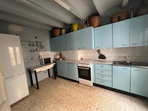 Cocina compartida con muebles azules, horno y frigorífico
