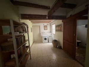Pasillo con estantería de libros y lavadero al fondo