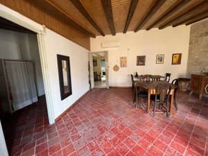 Salón comedor con techo de vigas y suelo de barro