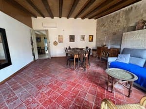 Salón con sofá azul, mesa y pared de piedra