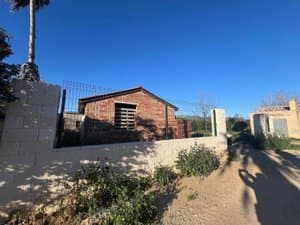 Muro de bloque con la caseta de ladrillo detrás