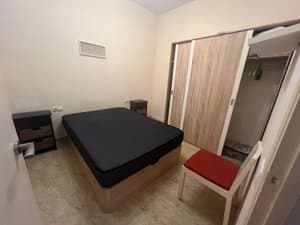 Zona de dormitorio con cama doble y armario de puertas correderas