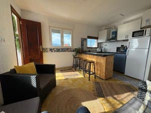 Salón con sofá, cocina y frigorífico