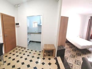 Entrada con puerta de madera y paso a la cocina