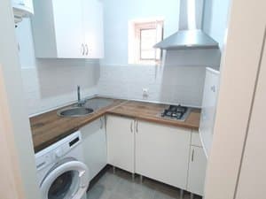 Cocina con placa, campana y lavadora
