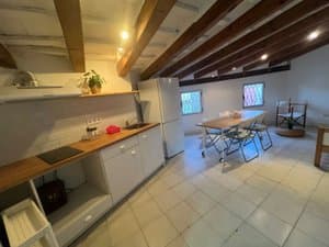Cocina con placa y frigorífico bajo las vigas