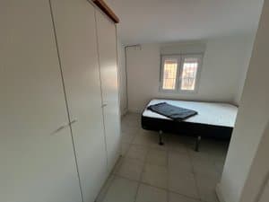 Dormitorio con armario blanco y ventana
