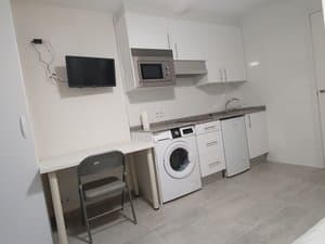 Zona de cocina y escritorio con televisor