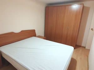 Dormitorio con cama de matrimonio y armario de madera