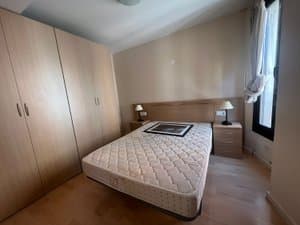 Dormitorio con armario de madera y ventana