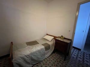 Dormitorio con cama individual y mesita