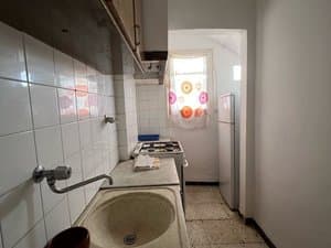 Cocina alargada con fregadero, cocina de gas y frigorífico
