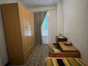 Dormitorio con armario de madera y salida al balcón