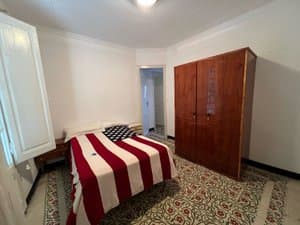 Dormitorio con cama de matrimonio y armario oscuro