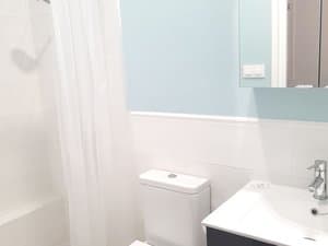 Baño con inodoro, lavabo y cortina de ducha