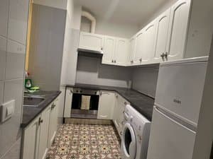 Cocina con encimera gris y muebles blancos