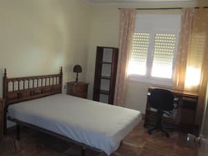 Dormitorio con cama, escritorio y ventana