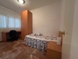 Dormitorio con cama, escritorio y armario