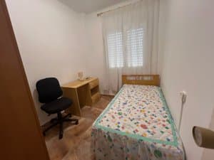 Dormitorio con cama individual y escritorio