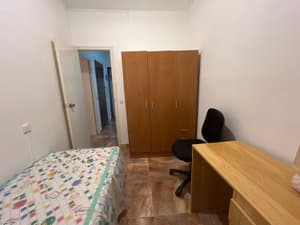 Dormitorio con armario de madera y escritorio