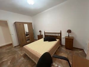 Dormitorio con cama de matrimonio y armario con espejo