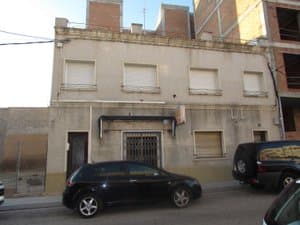 Fachada del edificio con coches aparcados delante