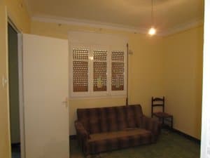 Salón con sofá y ventana con persiana