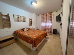 Dormitorio principal con cama de matrimonio y televisor
