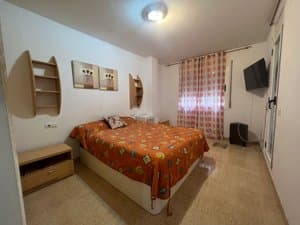 Dormitorio con cama de matrimonio y estantes