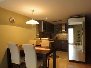 Comedor con mesa y cocina abierta al fondo