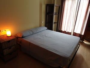 Dormitorio con cama de matrimonio y cortinas