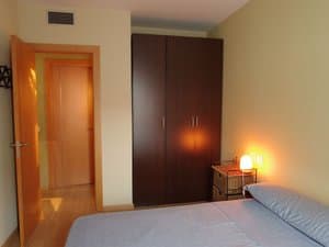 Dormitorio con armario oscuro y cama