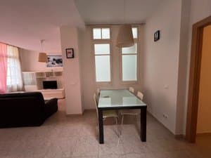 Comedor con mesa de cristal y ventanas