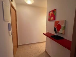 Recibidor con estante rojo y cuadro