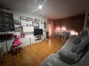 Salón con sofá, mueble de televisión y comedor