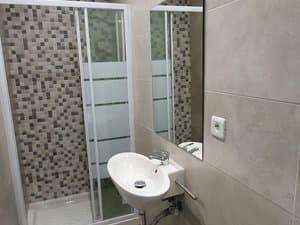 Baño con ducha de mampara y lavabo suspendido