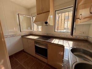 Cocina con horno, campana y ventanas