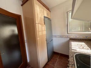 Cocina con frigorífico y armario