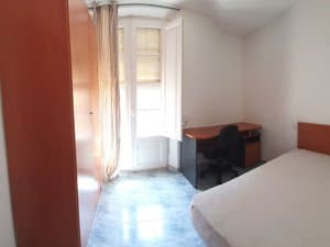 Dormitorio con escritorio y salida al balcón