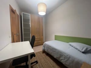 Habitación con cama, armario y lámpara