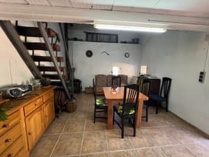 Comedor con mesa, aparador y escalera metálica