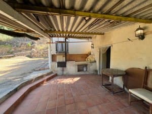 Porche con banco y puerta de la casa