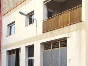 Fachada con balcón y puertas de garaje